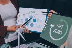 Two people holding up a folder with the word net zero on it photo
