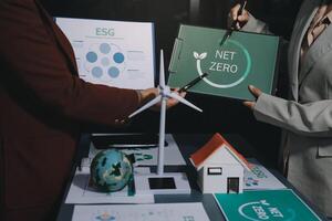 Two people holding up a sign that says net zero photo