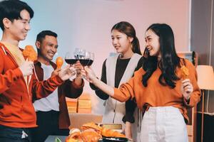 Four friends toasting wine glasses at a dinner table photo
