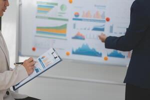 A woman in a business suit is writing on a clipboard photo