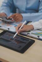 A person is using a tablet with a pen and paper photo