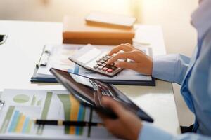 A person is using a calculator and a tablet photo