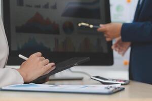 Business people using tablet computer and pen to write on paper photo
