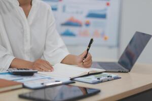 A woman is writing on a piece of paper while sitting at a desk photo