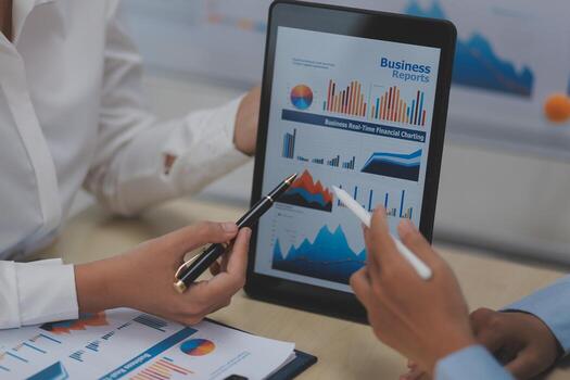 Business people using tablet to show graphs and charts photo