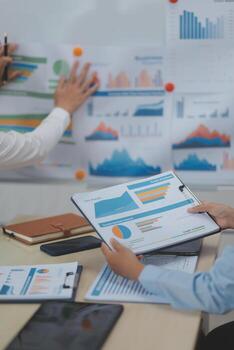 Business people working on a presentation with graphs and papers photo