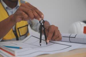 A man in a hard hat holding a compass and measuring tape photo