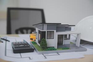 A model of a house sits on top of a desk photo