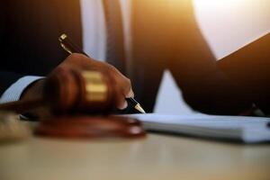 Lawyer writing on paper with a gavel photo