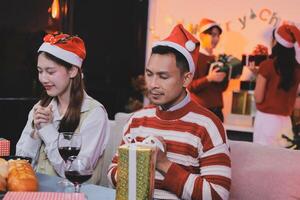 A man and woman sitting at a table with wine and gifts photo