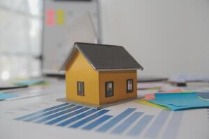 House model on desk with paper and sticky notes photo