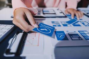 A person is working on a computer with blue and white paper photo