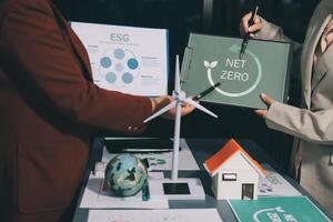Two people holding up a sign that says net zero photo