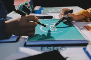 Two people are working on a document with a pen photo