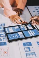 Two people working on a tablet with various design elements photo
