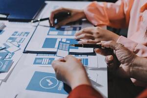 Two people working on a project with blue papers photo