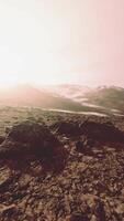 Snow covered rocky hill in middle of desert on cloudy day video
