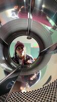 A person curiously looks inside a bright washing machine drum, playfully exploring laundry video