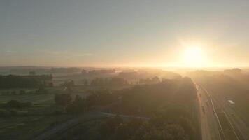 A sunrise over a highway with trees and grass video