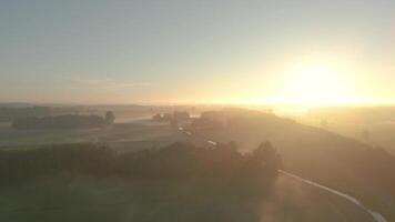 A sunrise over a field with trees and a river video