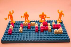 Yellow Mini Workers Standing on 1 May Toy Bricks photo