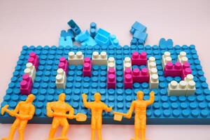 Toy Bricks Spelling 1 May with Mini Workers Labor Day Symbol photo