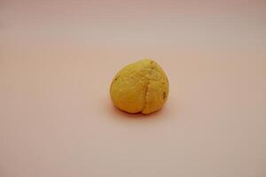 Shiny Avocado Stone Resting on a Soft-Toned White-Orange Background photo