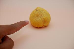 Clean and Smooth Avocado Pit Isolated on Soft Light Orange Backdrop photo