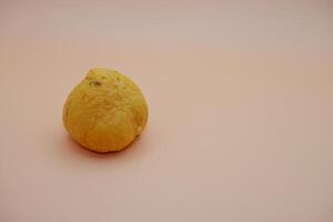 Single Avocado Seed Resting on a Warm White-Orange Background photo