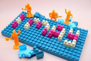 1 May Labor Day Concept with Toy Bricks and Mini Workers photo