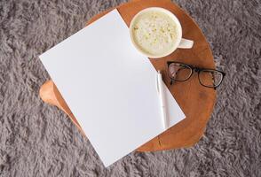 top view of blank paper sheet mockup on coffee table with green matcha latte photo