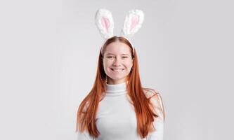 smiling woman wearing rabbit ears isolated over light white color background photo