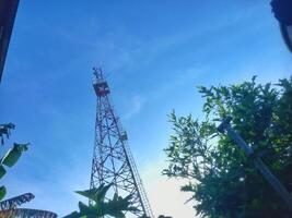 telecommunication tower on bright blue sky background photo