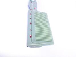 green hair comb isolated on white background photo