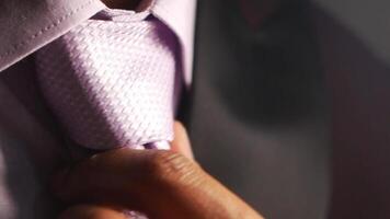 Man adjusting light purple tie in preparation for formal event video
