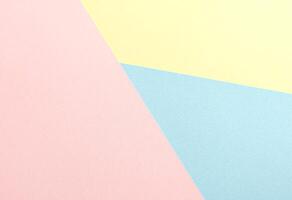 Pastel abstract geometric paper background featuring pink, yellow, and blue in a modern minimalist photo