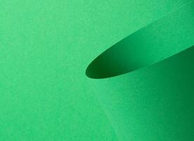 Eden green paper background with a smooth matte finish and curled, cylindrical shapes. Vivid, photo