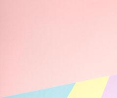 A pastel abstract background with a geometric arrangement of multicolored paper in soft tones, photo