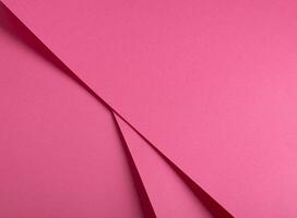 Pink yarrow paper background with a smooth matte finish and bent metallic accents. Vibrant, soft photo