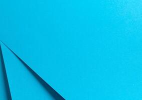 Blue paper background with a smooth matte finish and sharp geometric edges. Delicate pastel tones photo