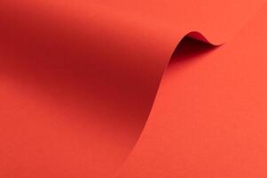 Fiesta red and orange paper background with a matte finish and smooth, curved folds. Vibrant, bold photo
