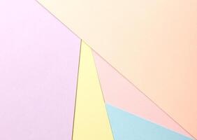 Pastel abstract geometric paper background featuring peach, lavender, yellow, pink, and blue in a photo