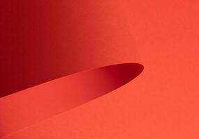 Fiesta red and orange paper background with a matte finish and smooth, curved folds. Vibrant, rich photo
