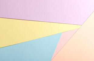 Pastel abstract geometric paper background featuring pink, yellow, blue, peach, and lavender in a photo