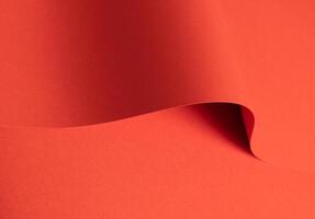Fiesta red and orange paper background with a matte finish and smooth, curved folds. Rich, saturated photo