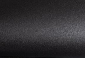Elegant black paper background with a smooth, textured surface, monochrome design creating a photo