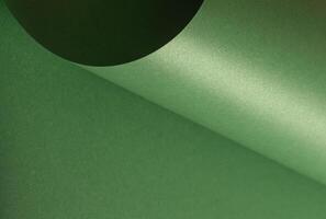 Green paper background with a smooth, glossy texture and elegant gradient effect. Blank surface with photo