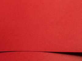 Red paper texture with a smooth matte finish. Blank and vibrant background with a rich, elegant photo