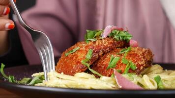 Crispy chicken served over creamy pasta in cozy dining setting video