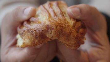 Enjoying a flaky pastry in a cozy cafe setting video